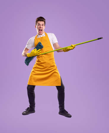 Funny housekeeper playing mop as guitarの写真素材