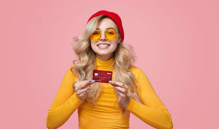Cheerful female showing credit cardの写真素材