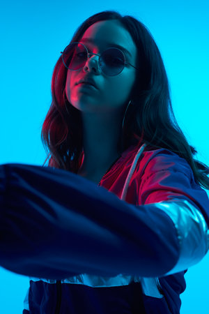 Cool teenage girl in studio with neon lights