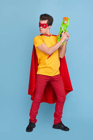 Funny superhero man with toy gunの写真素材