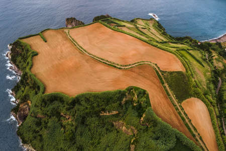 Scenic aerial view of agricultural fields at seasideの写真素材