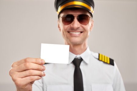 Cheerful captain showing business cardの写真素材