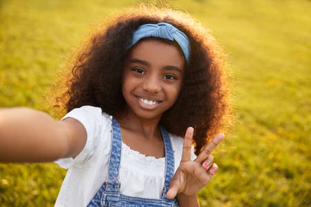 Content black girl taking selfie in parkの写真素材