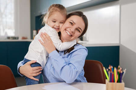 Daughter hugging mother at homeの写真素材