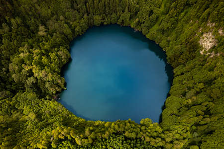Bright blue pond in woodsの写真素材