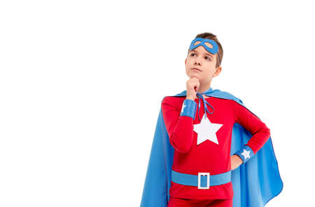 Thoughtful child in superhero costume looking awayの写真素材
