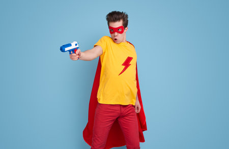 Funny superhero with water gun in studioの写真素材