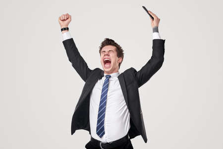 Businessman celebrating success with raised armsの写真素材
