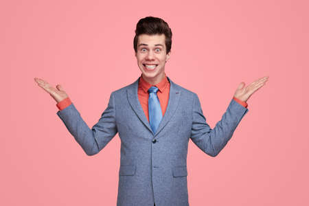 Funny businessman pointing with both hands in studioの写真素材