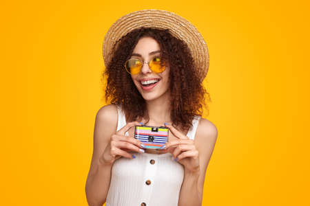 Traveling woman with retro camera in studio