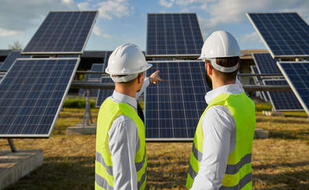 Technicians working in field with photovoltaic panels