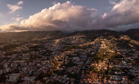 Picturesque mountainous town under cloudy sundown skyの写真素材