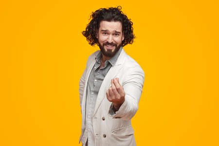 Smiling man showing money gesture in studioの写真素材