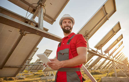 Engineer working in field with solar batteriesの写真素材