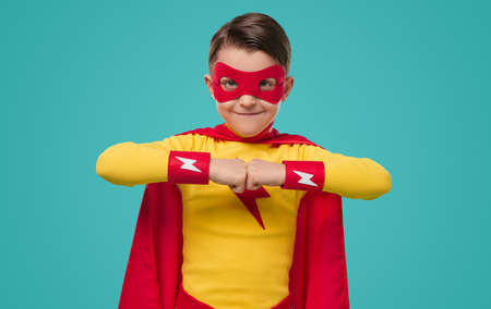 Content superhero boy bumping fists in studioの写真素材