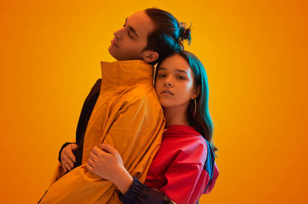 Teen couple in stylish clothes embracing in studioの写真素材