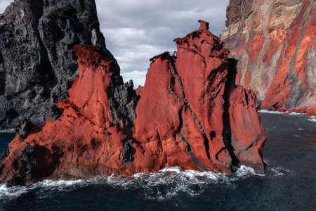 Red rocky formation in seaの写真素材