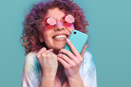 Excited woman in Holi powder celebrating success