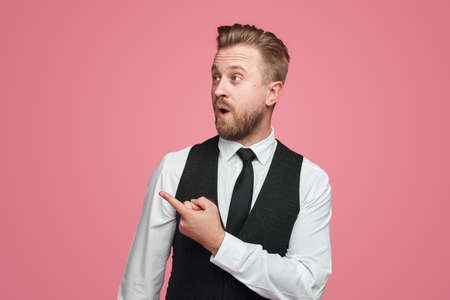 Astonished bearded businessman pointing awayの写真素材