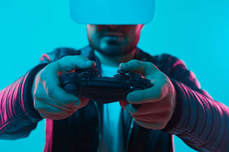 Man playing VR videogame under neon illuminationの写真素材