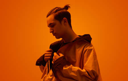 Trendy teen boy in studio with neon light