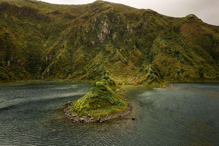 Rippling sea near green hilly shoreの写真素材