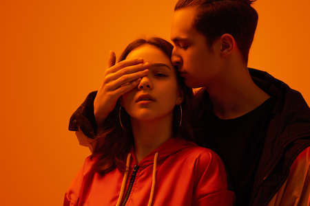 Tender teenage couple in studio with neon lightの写真素材