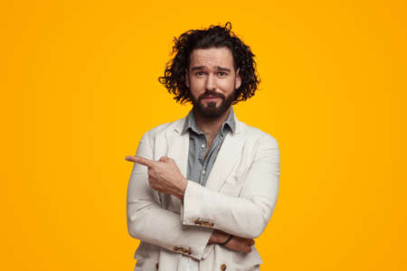 Stylish male pointing away in vibrant studioの写真素材