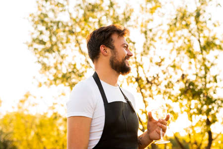Happy man enjoying wine in countrysideの写真素材
