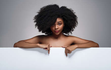 Black woman pointing at blank bannerの写真素材