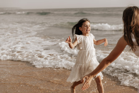 Child running to mom near seaの写真素材