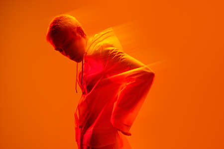 Trendy lady standing in bright studio with neon light