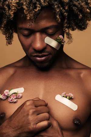 Black man with patches and flowers on woundsの写真素材