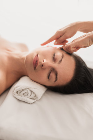 Crop beautician doing face care procedure to female clientの写真素材