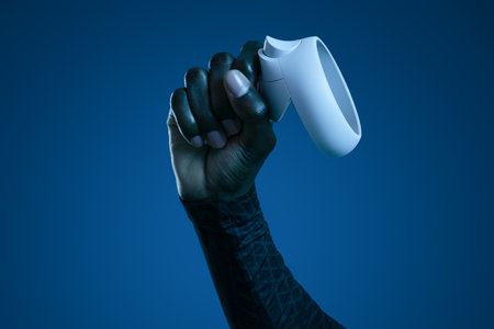 Crop anonymous black man with VR gamepad in blue studio