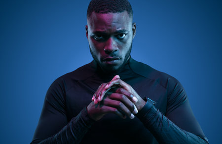 Serious black sportsman in neon lightの写真素材