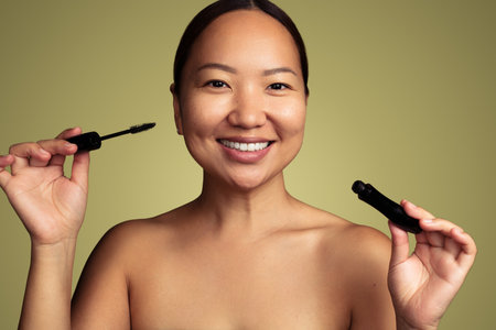 Smiling Asian woman with mascara in studioの写真素材