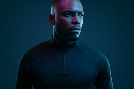 Pensive young black sportsman looking away in studioの写真素材