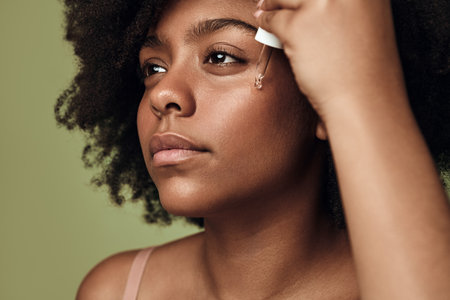 Black woman applying cream on faceの写真素材