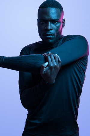 Motivated black sportsman stretching triceps during workoutの写真素材