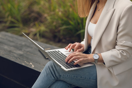 Crop businesswoman working on computer in parkの写真素材