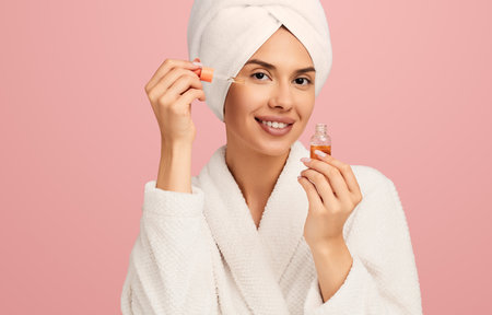 Happy woman applying hyaluronic acid on skinの写真素材