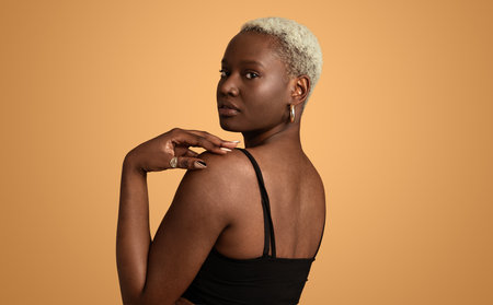 Thoughtful black woman looking over shoulder in studioの写真素材