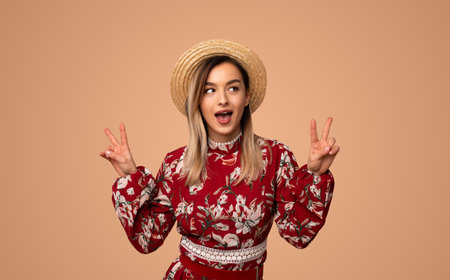 Happy woman in summer outfit showing peace signsの写真素材