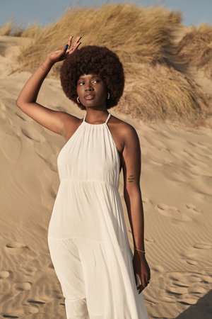 Black woman standing on sandy shoreの写真素材