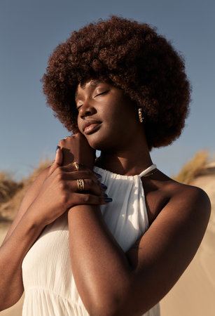 African lady caressing hand gently at dunesの写真素材