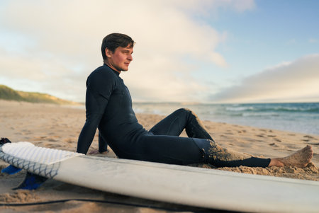 Surfer Relaxing on Sandy Beach After Morning Surf Session