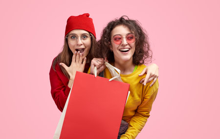 Excited Friends Shopping Together Holding Red Bagの写真素材