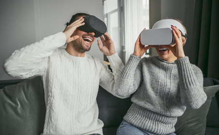 Couple Enjoying Virtual Reality Headsets in Living Roomの写真素材