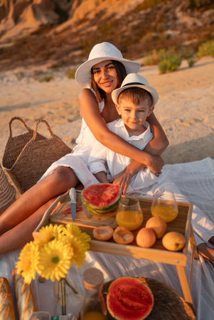 Mother and Son Enjoying a Summer Picnic on the Beachの写真素材